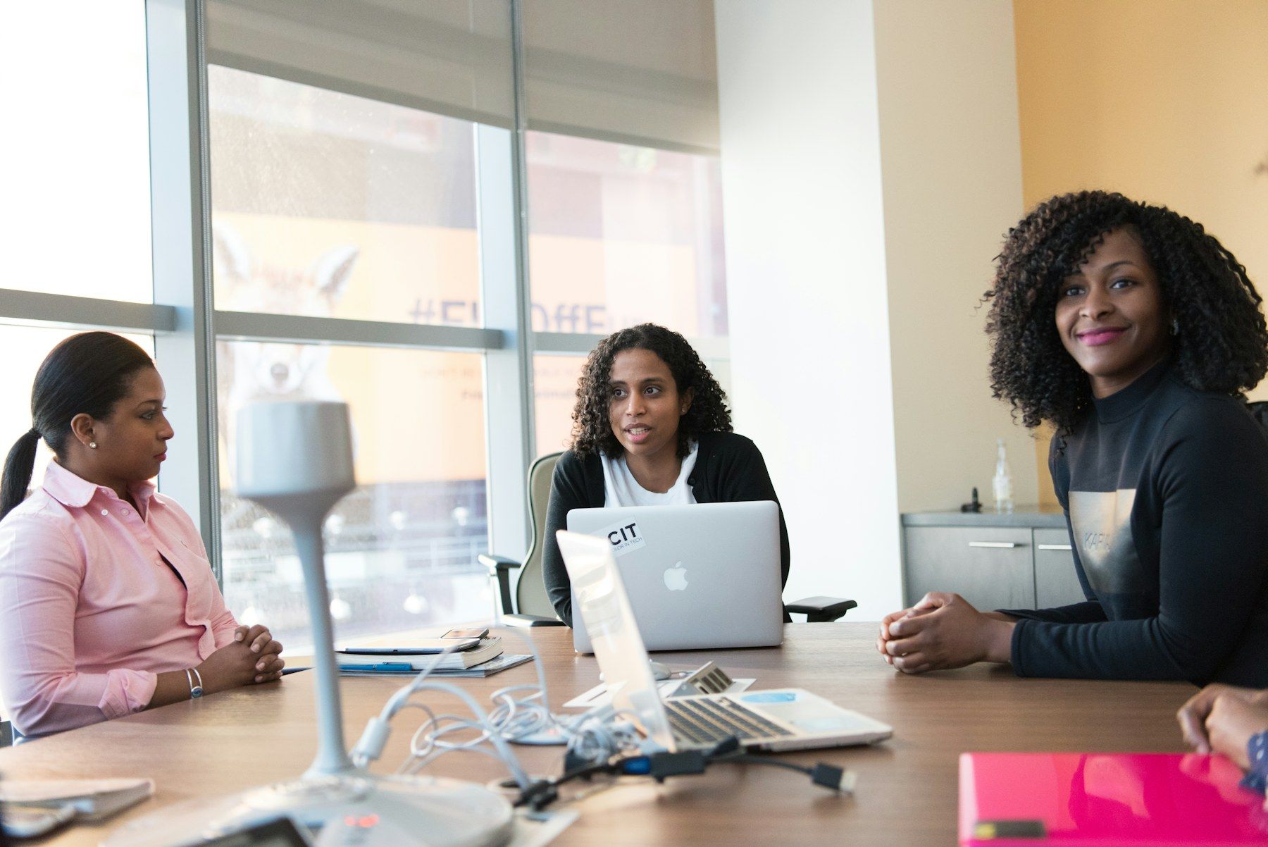 Three women in a working session around a table